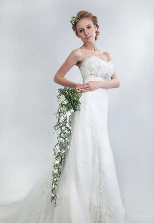 Beautiful bride blond with floral bouquet of live tender flowers の写真素材