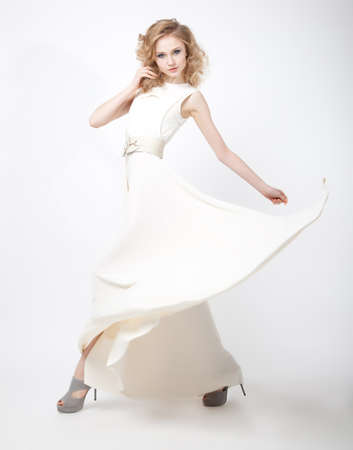 Sexy young lovely female blond hair with flying vernal dress isolated over white backgroundの写真素材