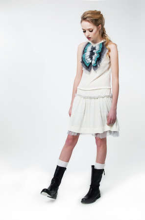 Fashion style - beautiful brunette slim girl in white dress posing on podiumの写真素材