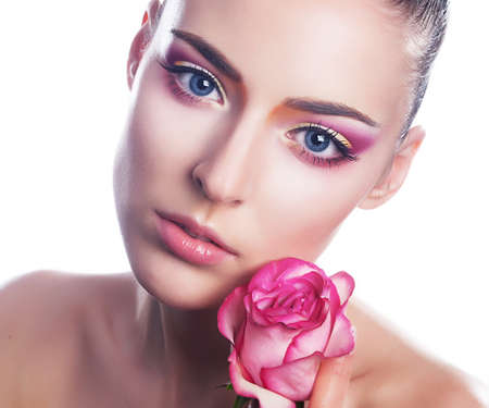 Beautiful young woman with pink rose close up beauty portraitの写真素材