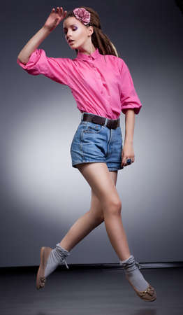 Motion - active girl in elegant jeans shorts, studio shotの写真素材