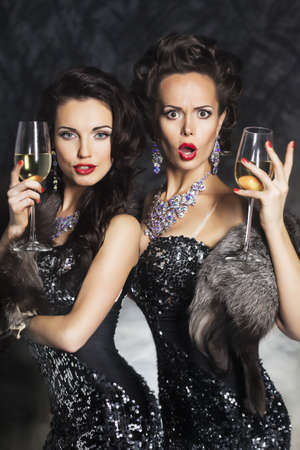 Two beautiful young women drinking champagne in night club. Merry Ð¡hristmas!の写真素材