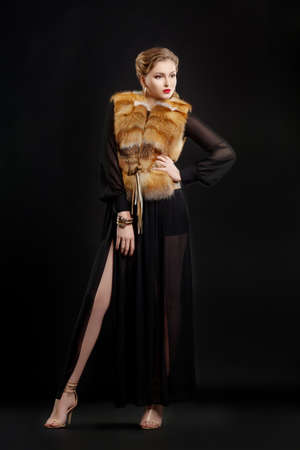Fashionable Woman in Luxury Fur Coat  over Black Backgroundの写真素材