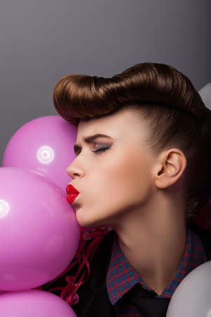 Emotional Comical Woman with Colorful Air Balloons Grimacingの写真素材