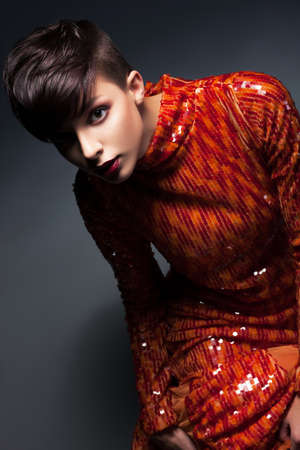 Charm  Chic Young Woman in Red Evening Gown posingの写真素材