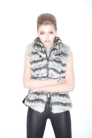 Stylish Trendy Young Woman in Fur Waistcoat and Leggings Posing in Studioの写真素材