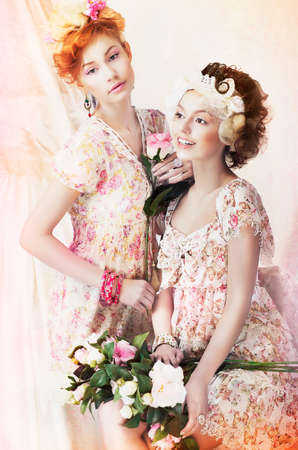 Freshness. Two Young Pretty Women in Classic Vintage Dresses with Flowers. Pin-up Styleの写真素材