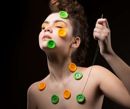 Tailor. Artistic Woman with Colorful Buttons and Needle for Sewingの写真素材