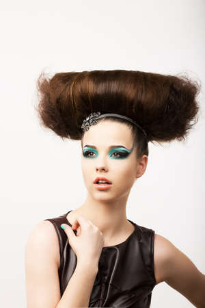 Glamour. Vitality. Portrait of Unusual Brunette with Extraordinary Festive Hairdoの写真素材
