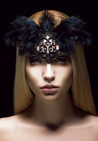 Beautiful Genuine Woman in Styled Black Mask with Feathers. Aristocratic Faceの写真素材