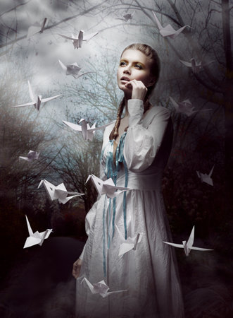 Night. Woman in  Mysterious Forest launching handmade paper Cranes. Origamiの写真素材