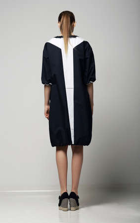 Rear View of of Trendy Chichi Woman in White-Black Contrast Raincoat. Vogueの写真素材