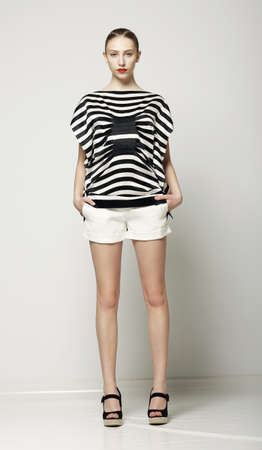 Full Length of Trendy Woman in Shorts and Grey Striped Shirt. Casual Modern Collectionの写真素材