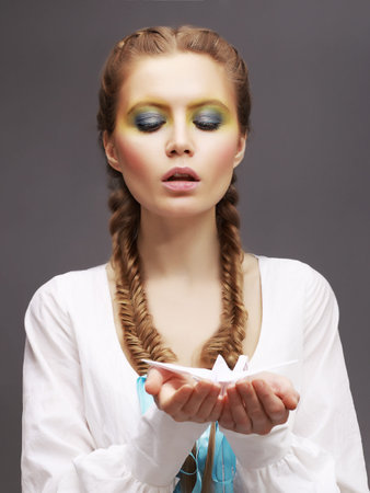 Aspiration. Caucasian Woman in White Dress releasing Origami Pigeon. Kindness
