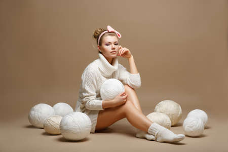 Housework. Young Woman in White Tricot with Woolen Balls. Seamstressの写真素材