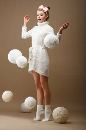Falling Skeins  Surprised Woman in Woolen Knitted Jersey with White Balls of Yarnの写真素材