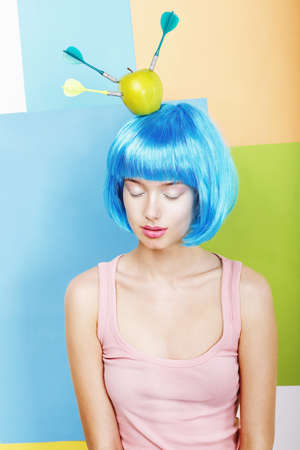 Joke  Eccentric Woman Oddball in Blue Wig with Darts and Green Appleの写真素材