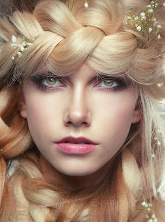 Closeup Portrait of Young Woman with Tress and Flowersの写真素材