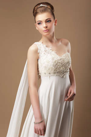 Femininity. Gentle Woman in Lacy Dress over Beige Backgroundの写真素材