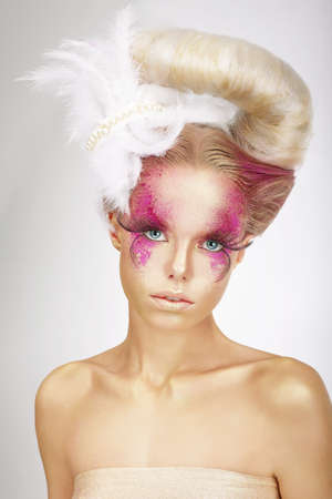 Faceart. Blonde with Skin Colored Pink, False Lashes and White Featherの写真素材