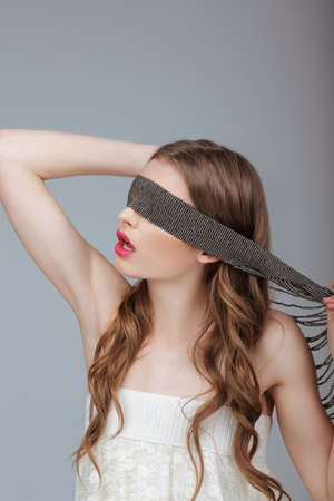Hide and Seek. Woman Holding a Strap on her Face. Puzzleの写真素材