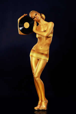 Woman Painted Gold With Vinyl Recordの写真素材