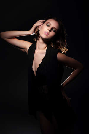 Model posing on a dark background, shadow, lighting.の写真素材