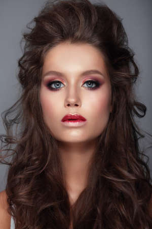 Beautiful young female face with bright fashion multicolored make-up.の写真素材