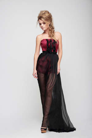 Beautiful woman model posing in elegant dress in the studio.の写真素材