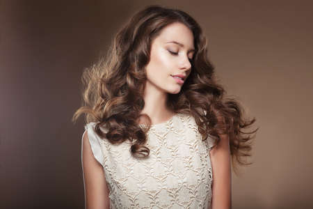 Sensual young woman with beautiful long brown flying hairs.の写真素材
