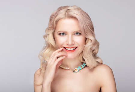 Portrait of pretty smiley model. Fingers on lips.の写真素材