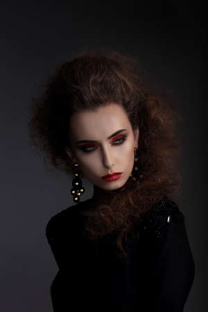 Fashionable woman with high hair, a photo session in the studio. Red lips, professional makeup.の写真素材