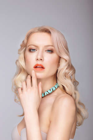 Portrait of a beautiful blonde woman, hand near lips.の写真素材