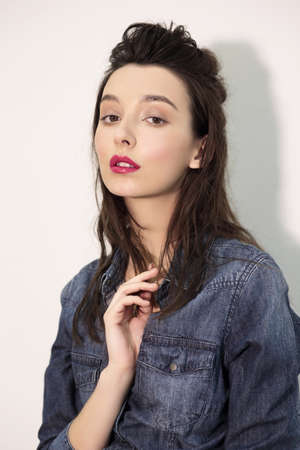 Fashion looks. Young model posing in denim shirt.の写真素材
