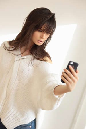 Young woman or teenage girl taking selfie with smartphone.の写真素材