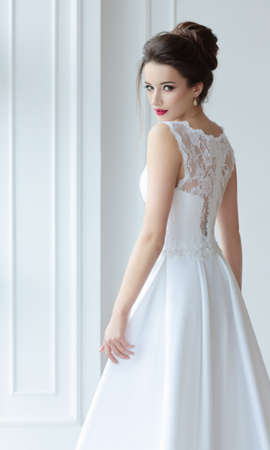 The bride in a magnificent white dress stands back and looks over his shoulder.の写真素材