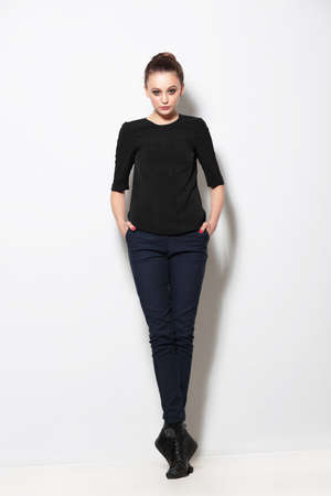 Full length casual young girl  posing on light background.の写真素材