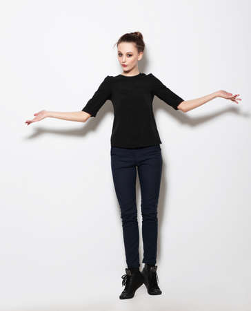 Young girl model posing in the studio full-length. Hands to the side.の写真素材