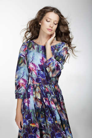 Portrait of a cute young woman with long hair in dress.の写真素材