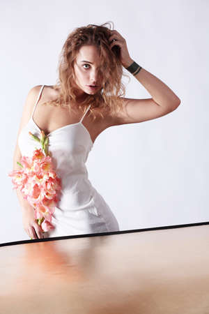 Young beautiful woman with a bouquet of flowers, posing near the reflector.の写真素材