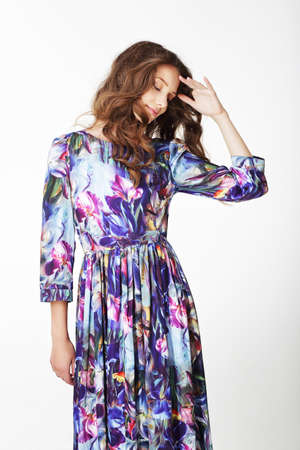 Beautiful young woman in dress looking down.の写真素材