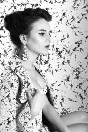 Black and white portrait of a young woman. Clothing and background patterns blots and stains.の写真素材