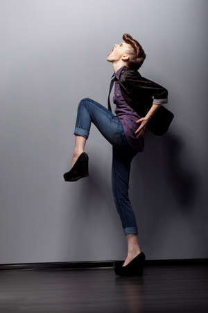 A young woman in full growth poses in the studio. Step. Emotions.の写真素材