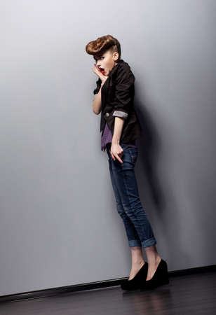 A young woman in full growth poses in the studio. Emotions. Amaze.の写真素材