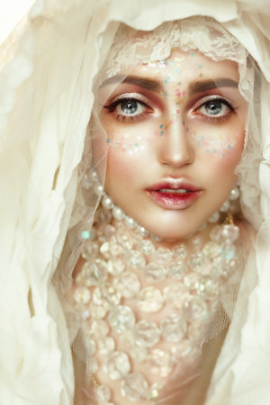 Portrait of a young beautiful woman with big eyes. A princess. Doll.