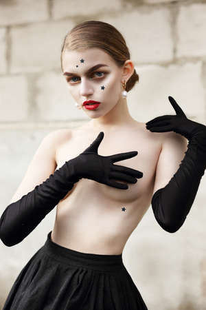Portrait of a young beautiful woman with big eyes. Hands in long black gloves. Doll.の写真素材