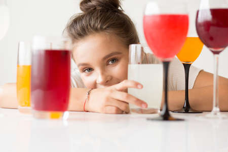 Girl smiling, Multicolored glasses of juices and drinks.の写真素材