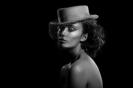 Black and white portrait of a young woman in a hat with a veil. Vintage style. Beautiful lady.の写真素材