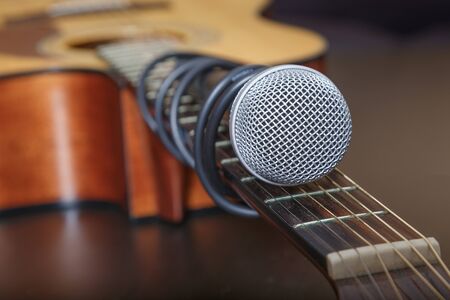 Microphone attached to the guitar neck by cord. Soft focus. Focused only on microphone head.の写真素材