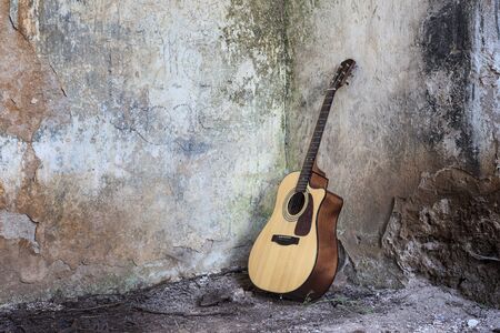 Guitar standing on the floor in a ruined house.の写真素材